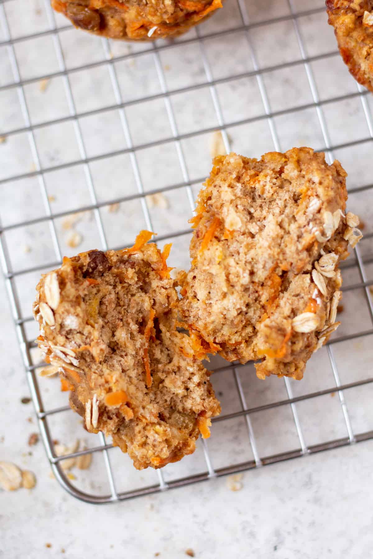 a sliced open carrot muffin on a cooling rack