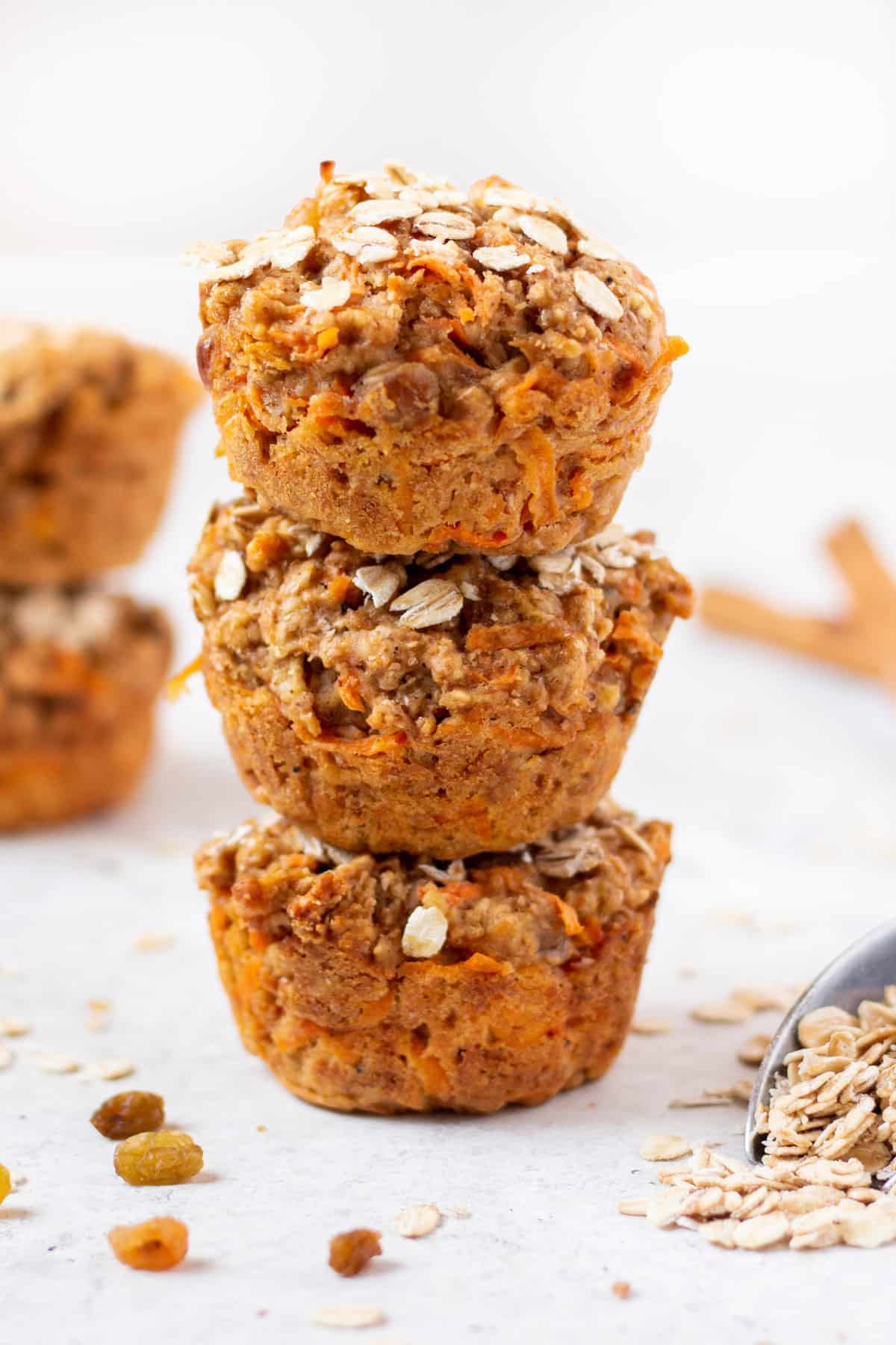 whole wheat carrot muffins in a stack of 3 on a white background