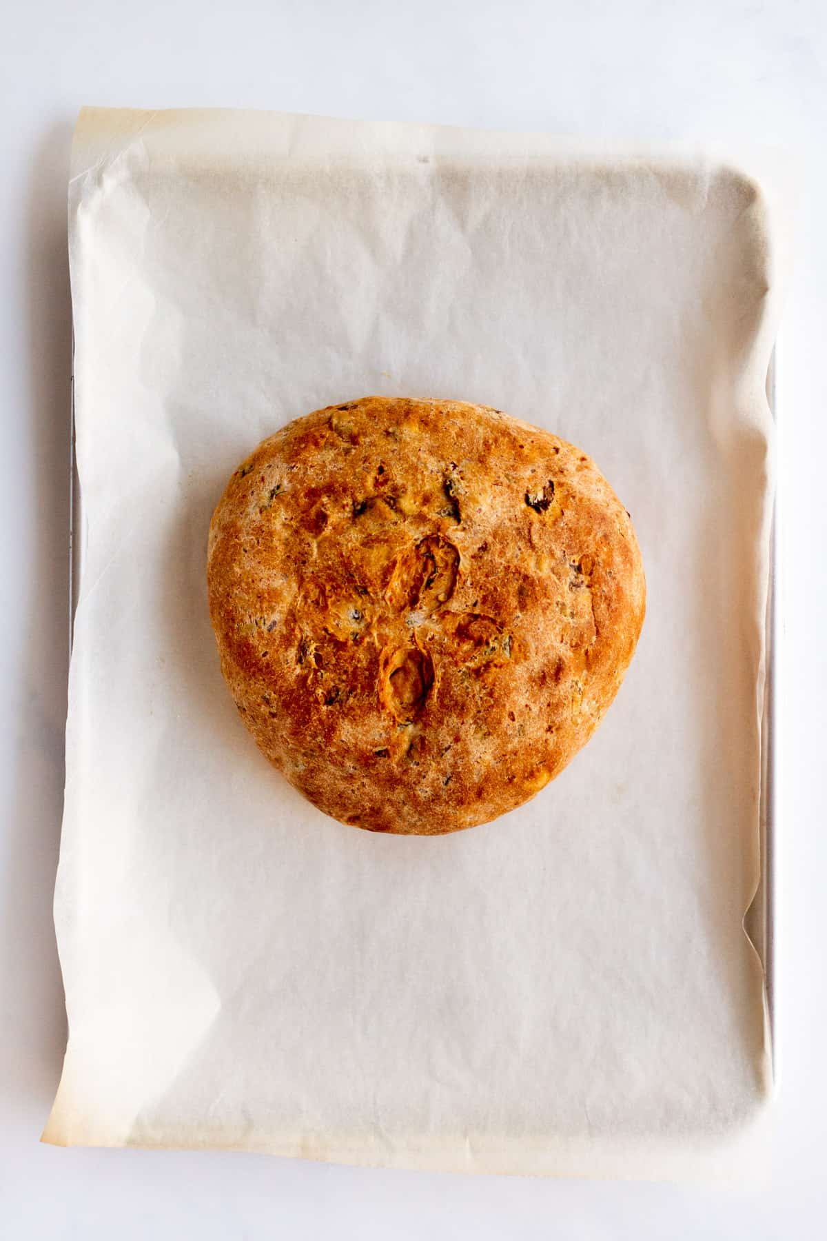 baked tomato basil bread on parchment paper