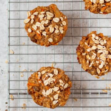 healthy carrot muffins topped with oatmeal on a cooling rack