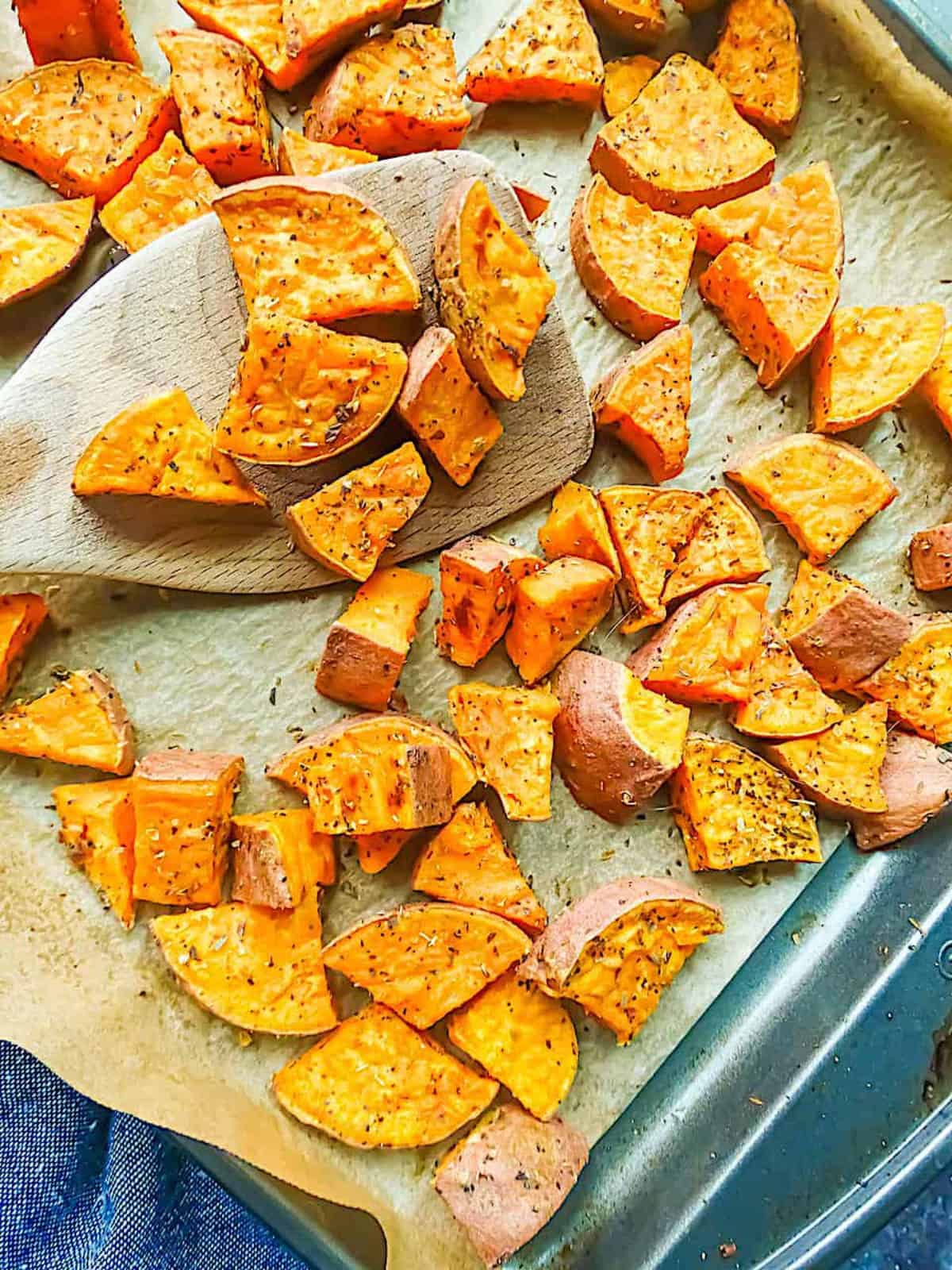 crispy roasted sweet potato cubes on a baking sheet