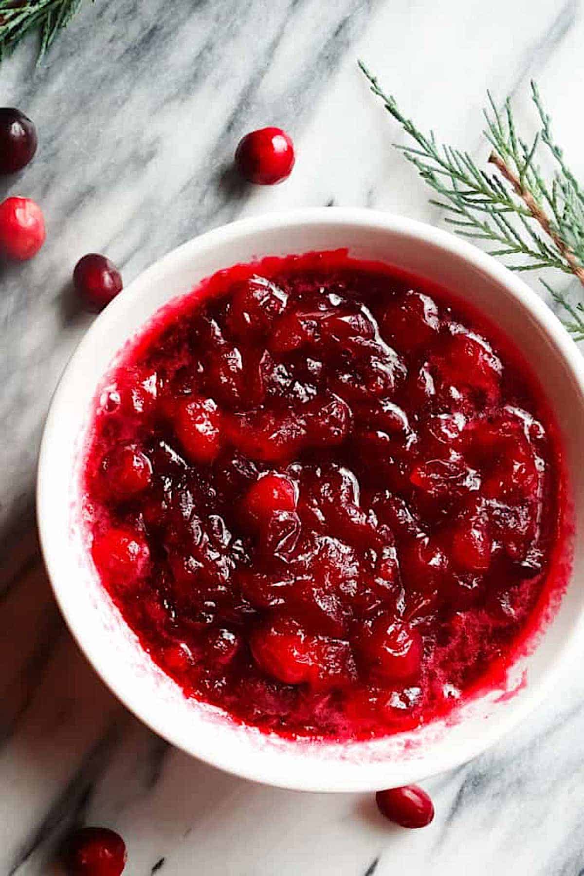 fresh cranberry sauce in a white bowl on a marble board