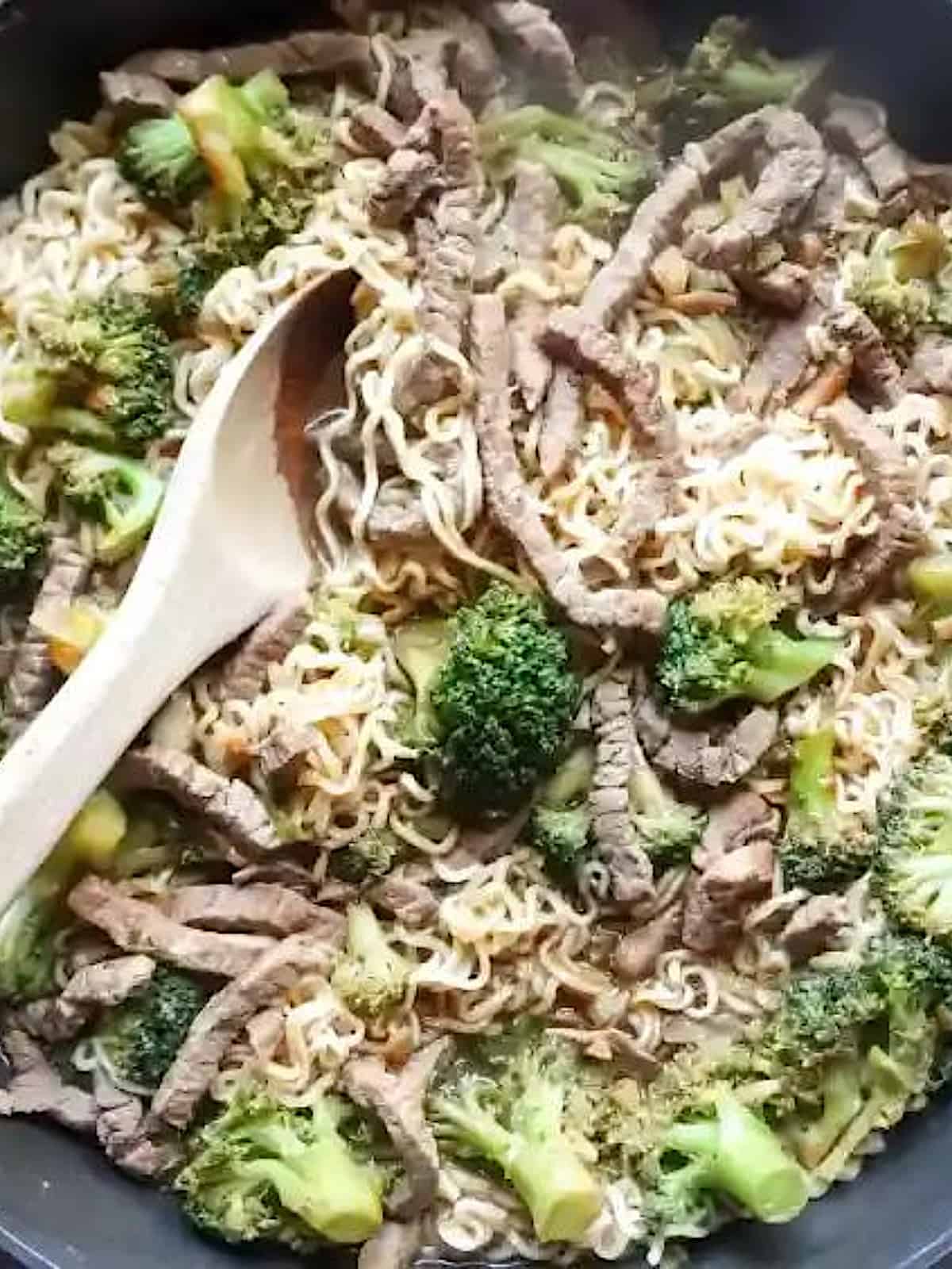 beef and broccoli with ramen noodles in a skillet
