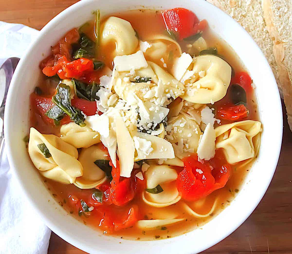 spinach tortellini soup in a white bowl