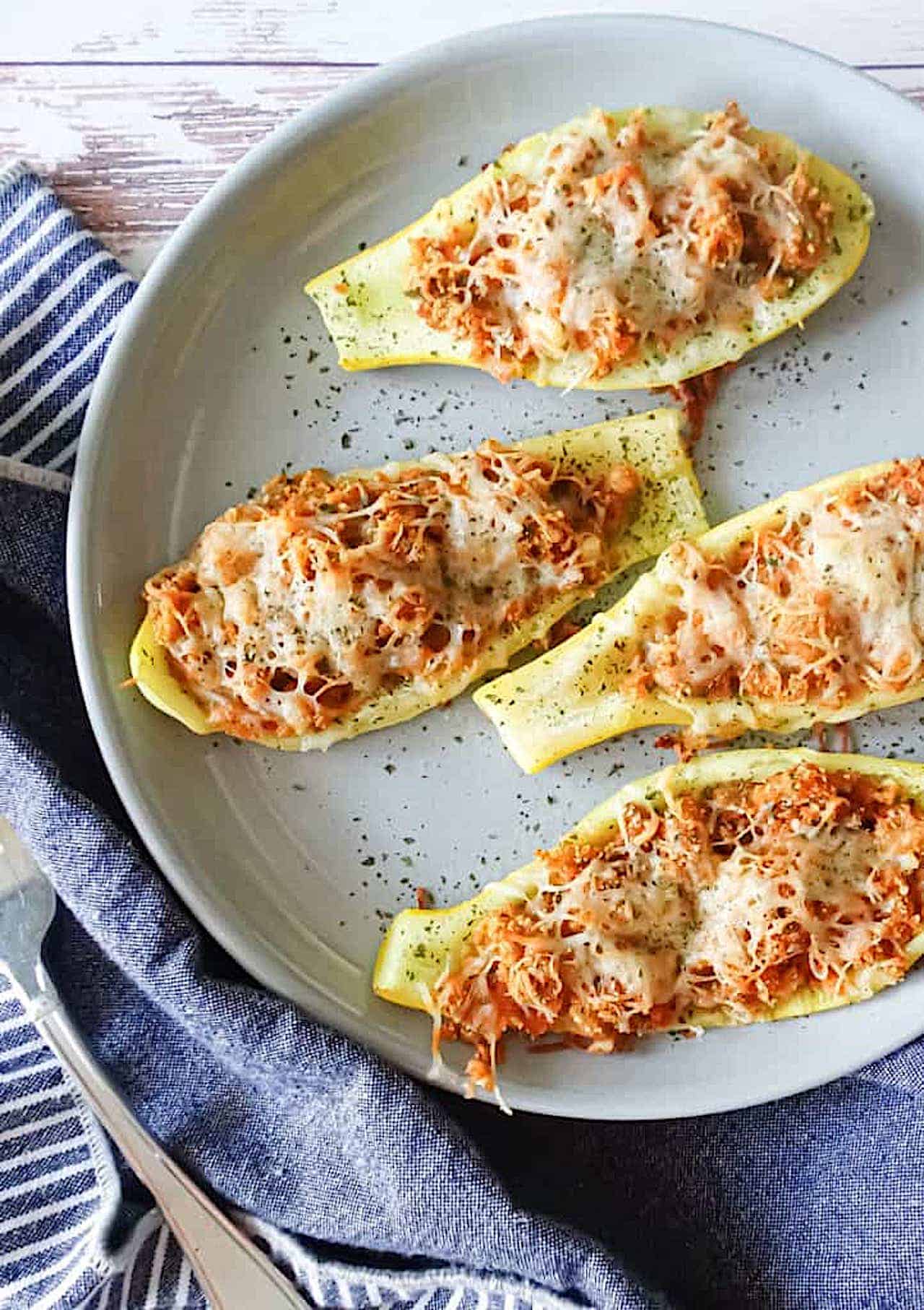 cheesy roasted squash boats on a gray plate 