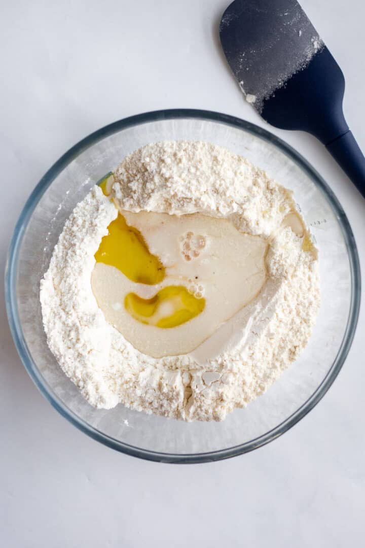 eggs and milk in a bowl of flour