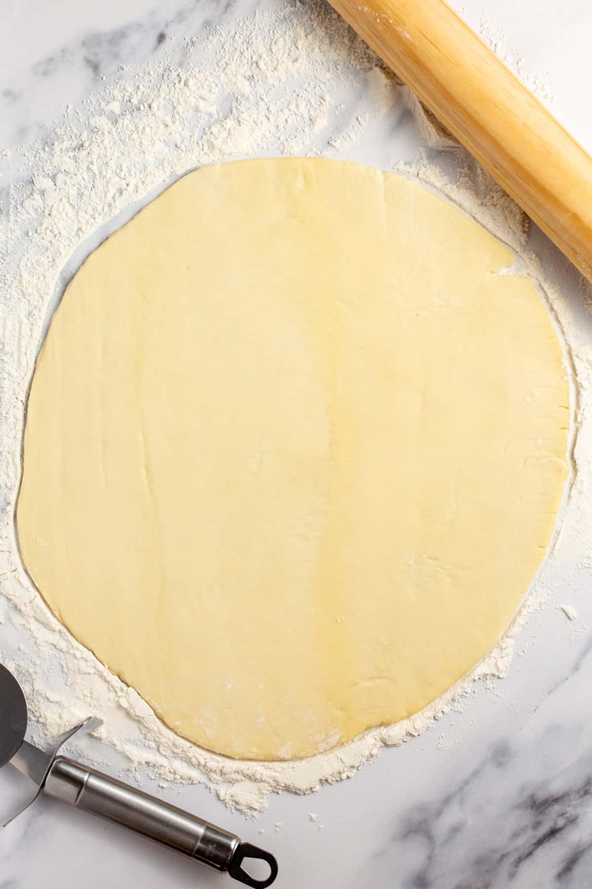 pizza dough rolled flat on the counter