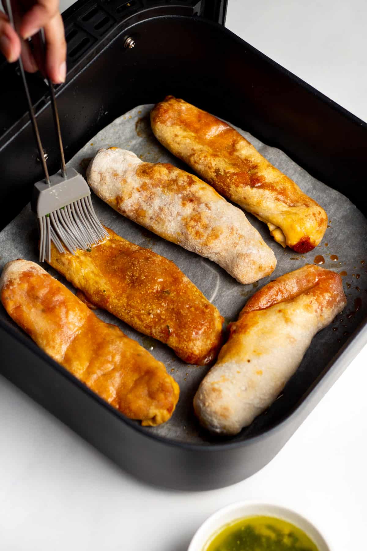 pizza sticks being brushed with garlic butter sauce