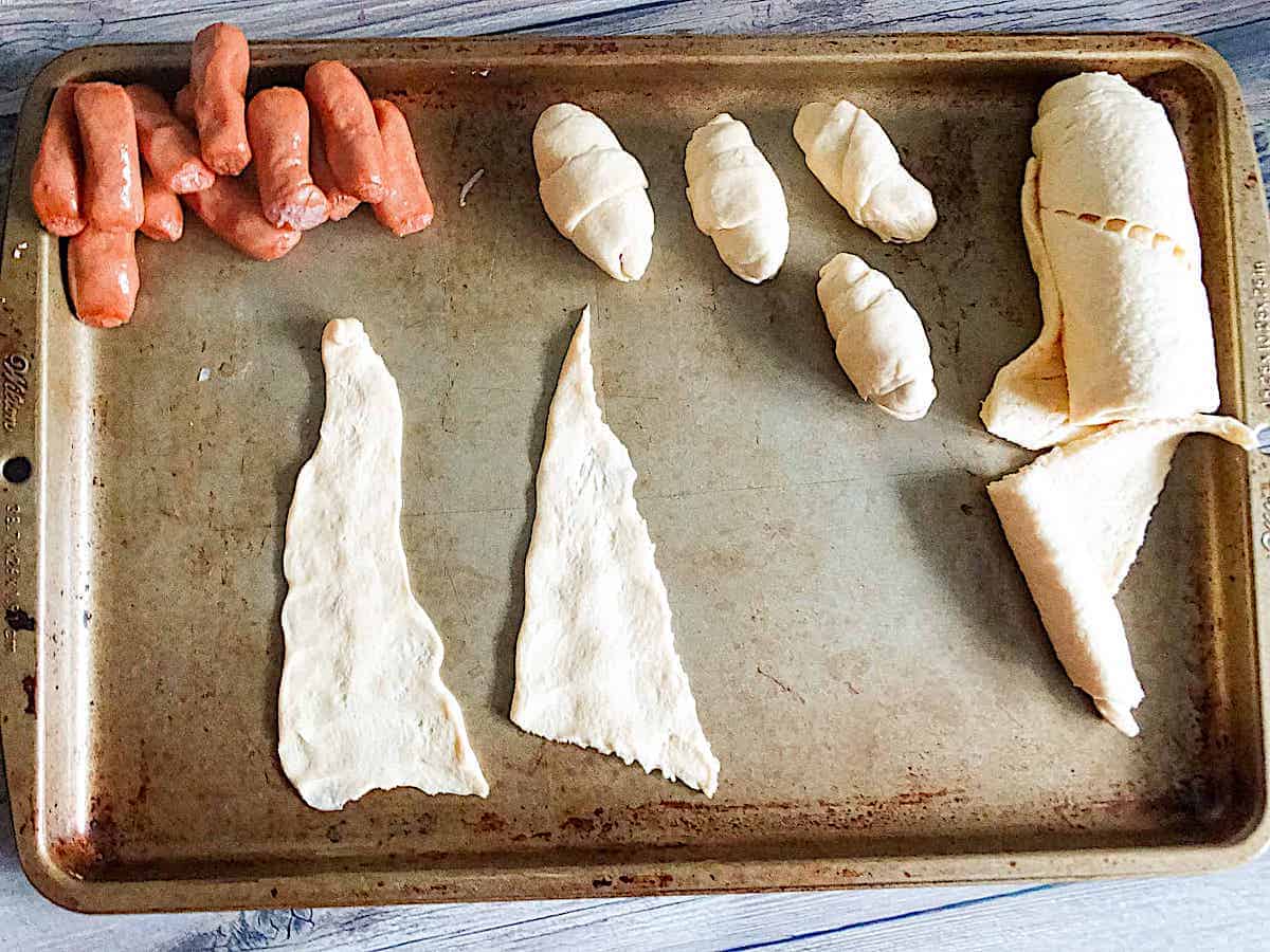 crescent rolls, hot dogs, and wrapped hot dogs on a baking sheet