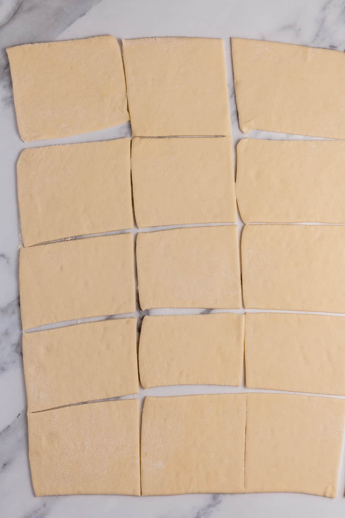 pizza dough cut into squares on a cutting board