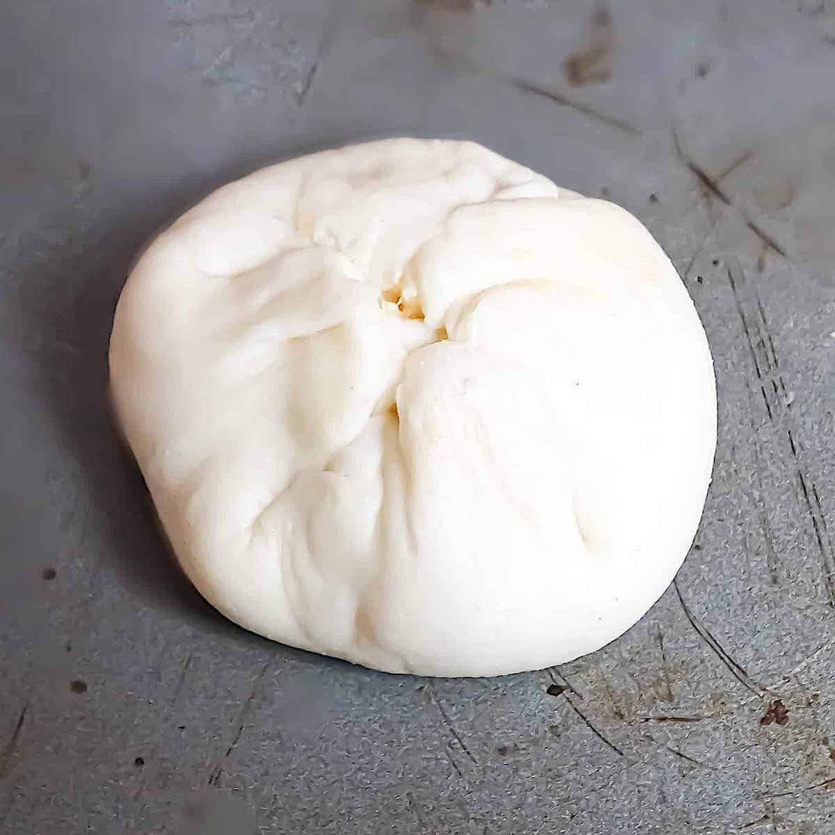 dough shaped into a ball on a baking sheet