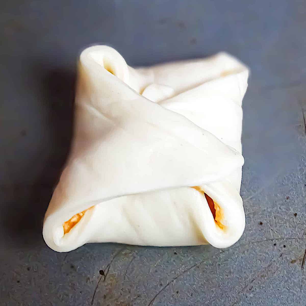 a folded pizza dough square