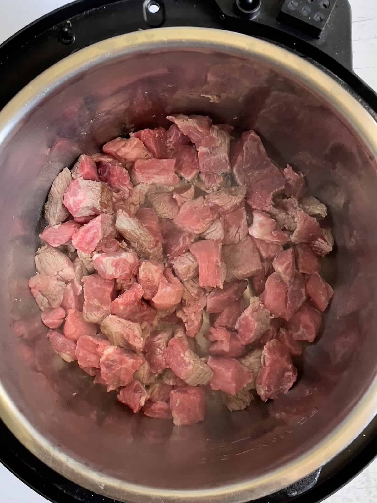 stew meat cooking in a pressure cooker