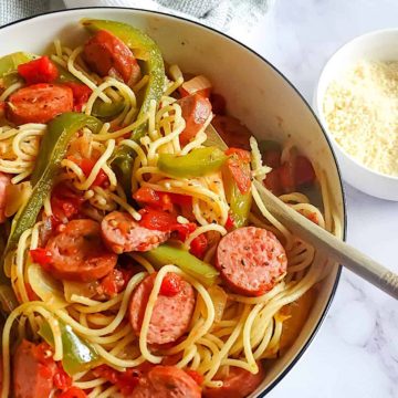 kielbasa and pepper pasta in a serving bowl with parmesan cheese