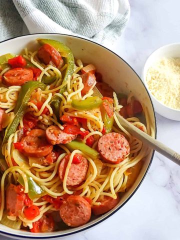 kielbasa and pepper pasta in a serving bowl with parmesan cheese