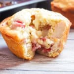 strawberry cheesecake muffin with a bite on a wooden background