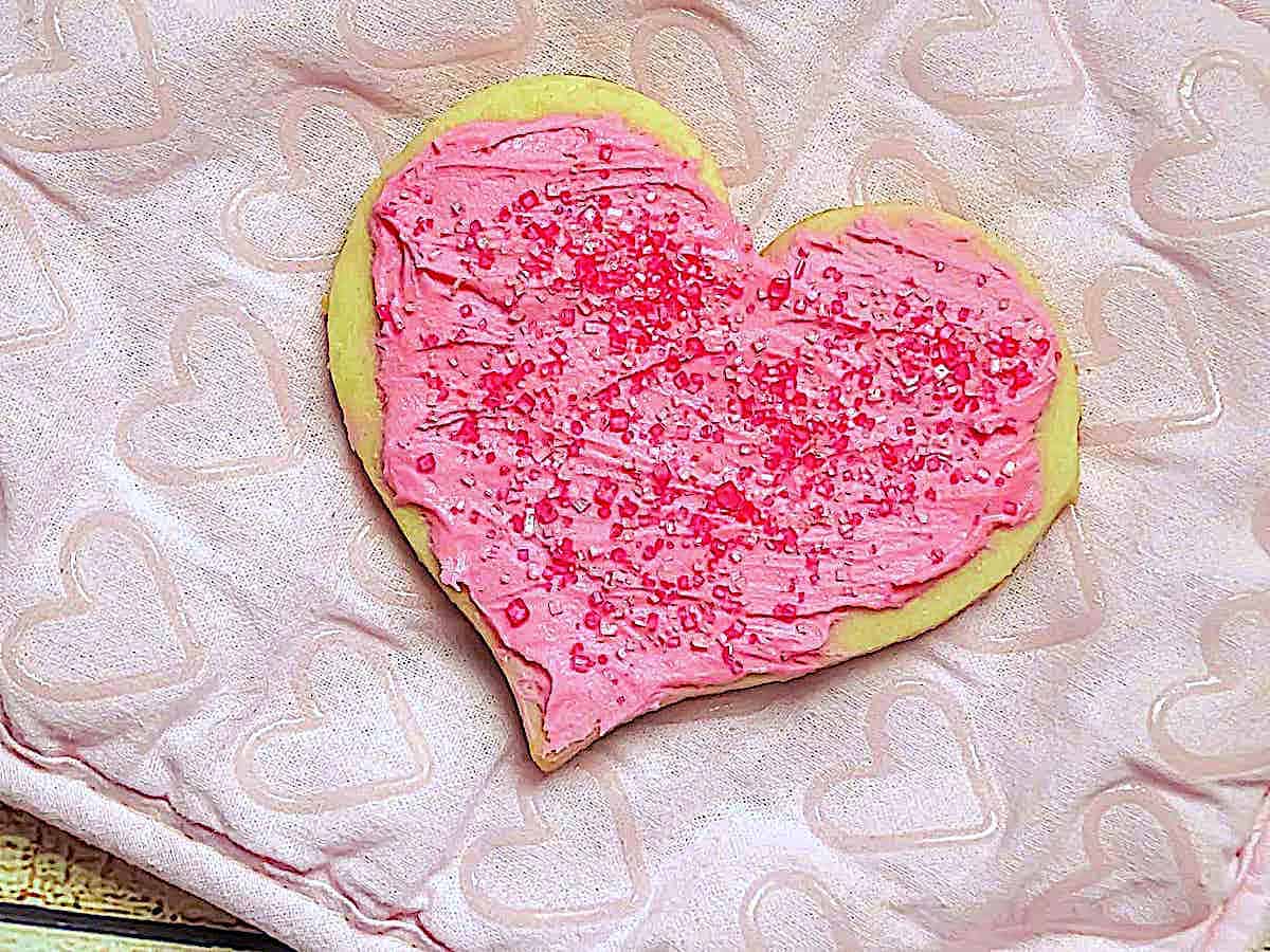 heart shaped cookie topped with icing and sprinkles