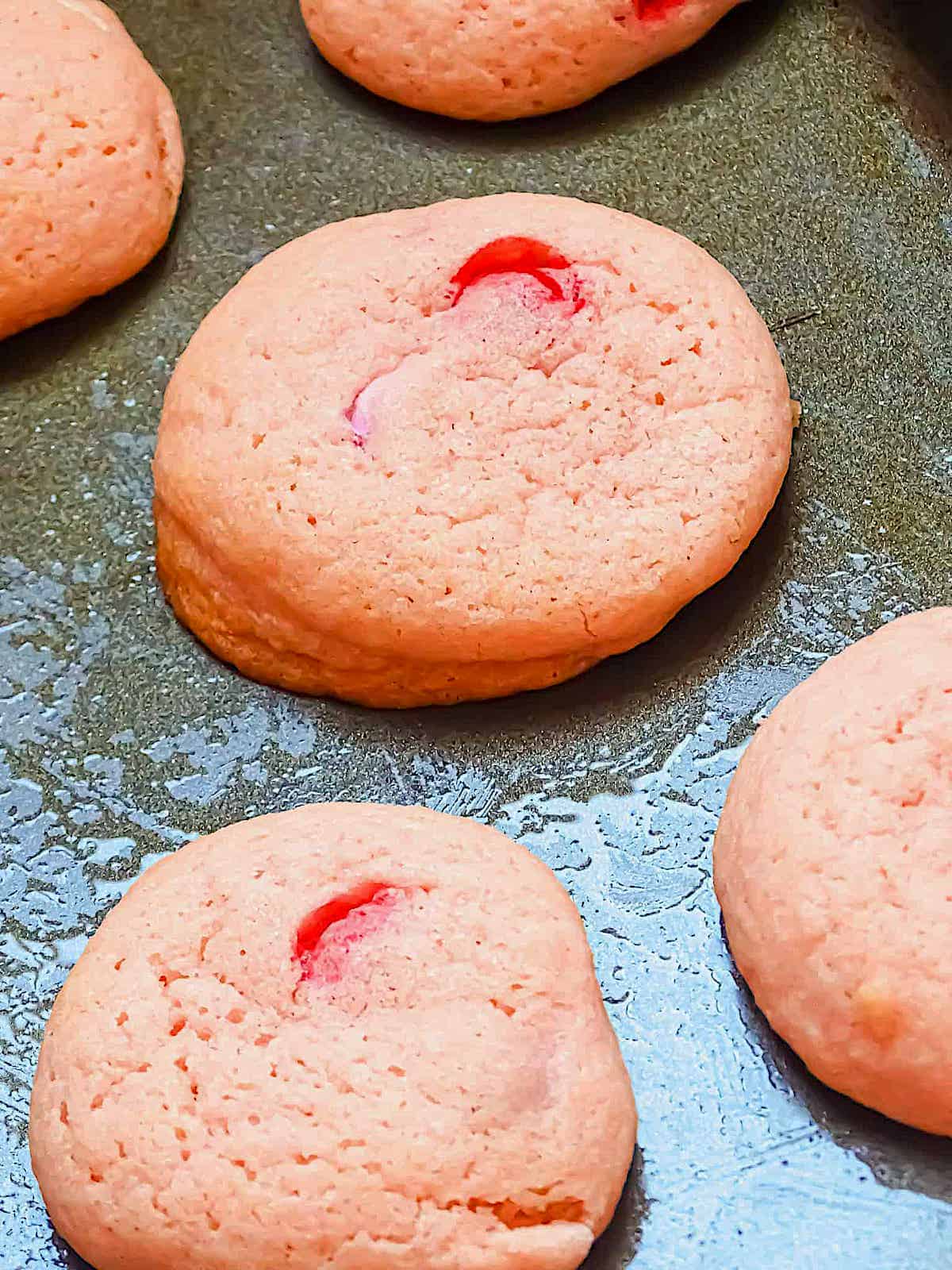 pink sugar cookies baked on a baking sheet