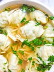 Instant Pot wonton soup with spinach in a white bowl