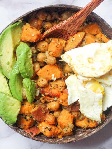 sweet potato chickpea hash bowl topped with egg and avocado