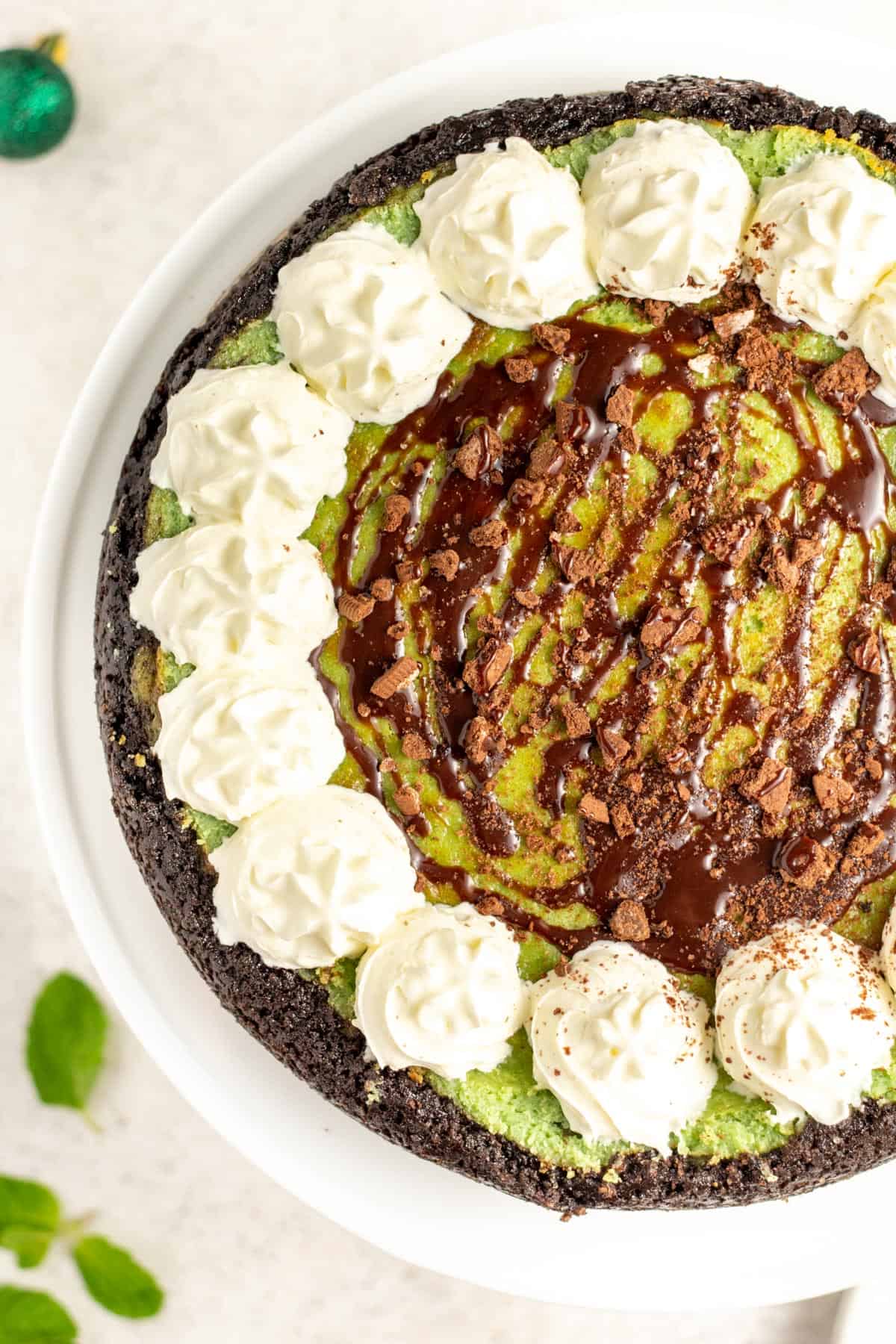 mint chocolate cheesecake covered with whipped cream and chocolate