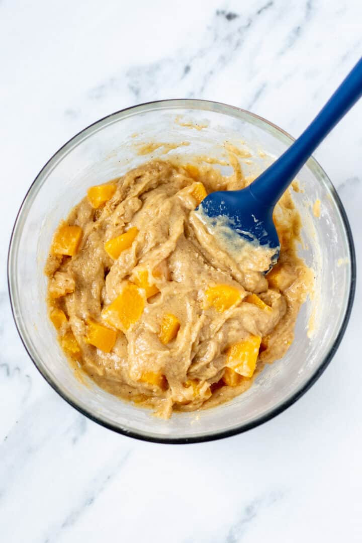 peach muffin batter in a large mixing bowl