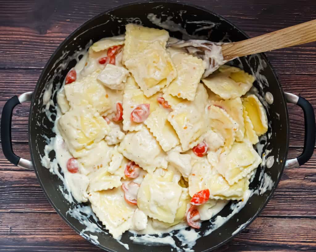 creamy one pot pasta with tomatoes and chicken in a wok