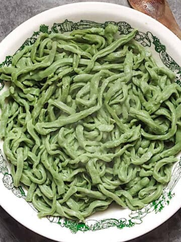 bread machine spinach pasta dough in a white bowl