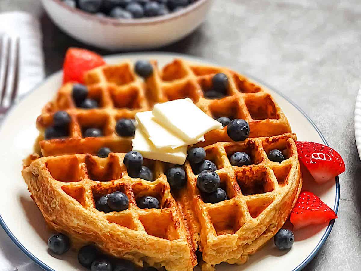 cottage cheese waffles on a plate topped with fruit and butter