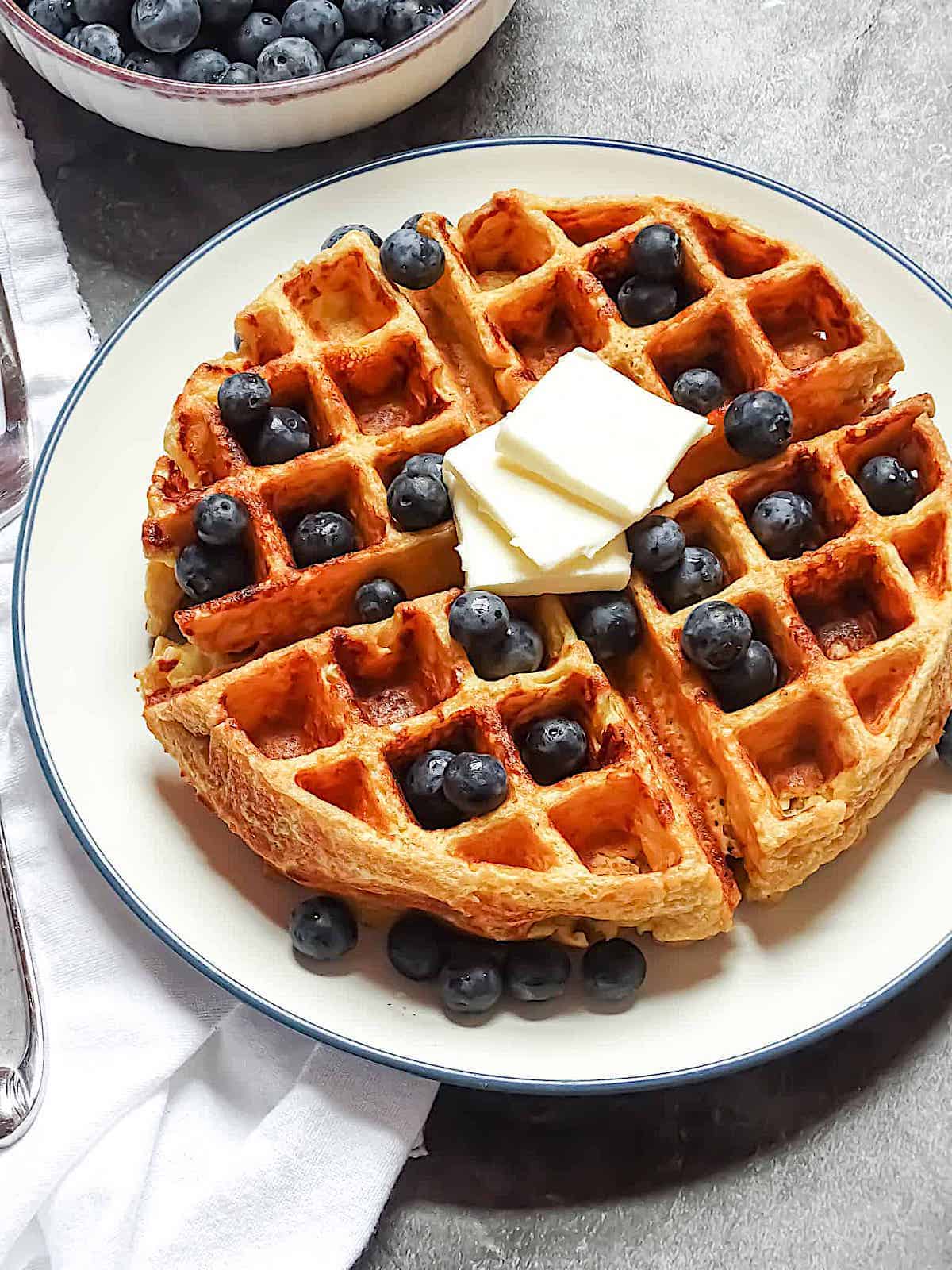 belgian waffles served with blueberries and butter