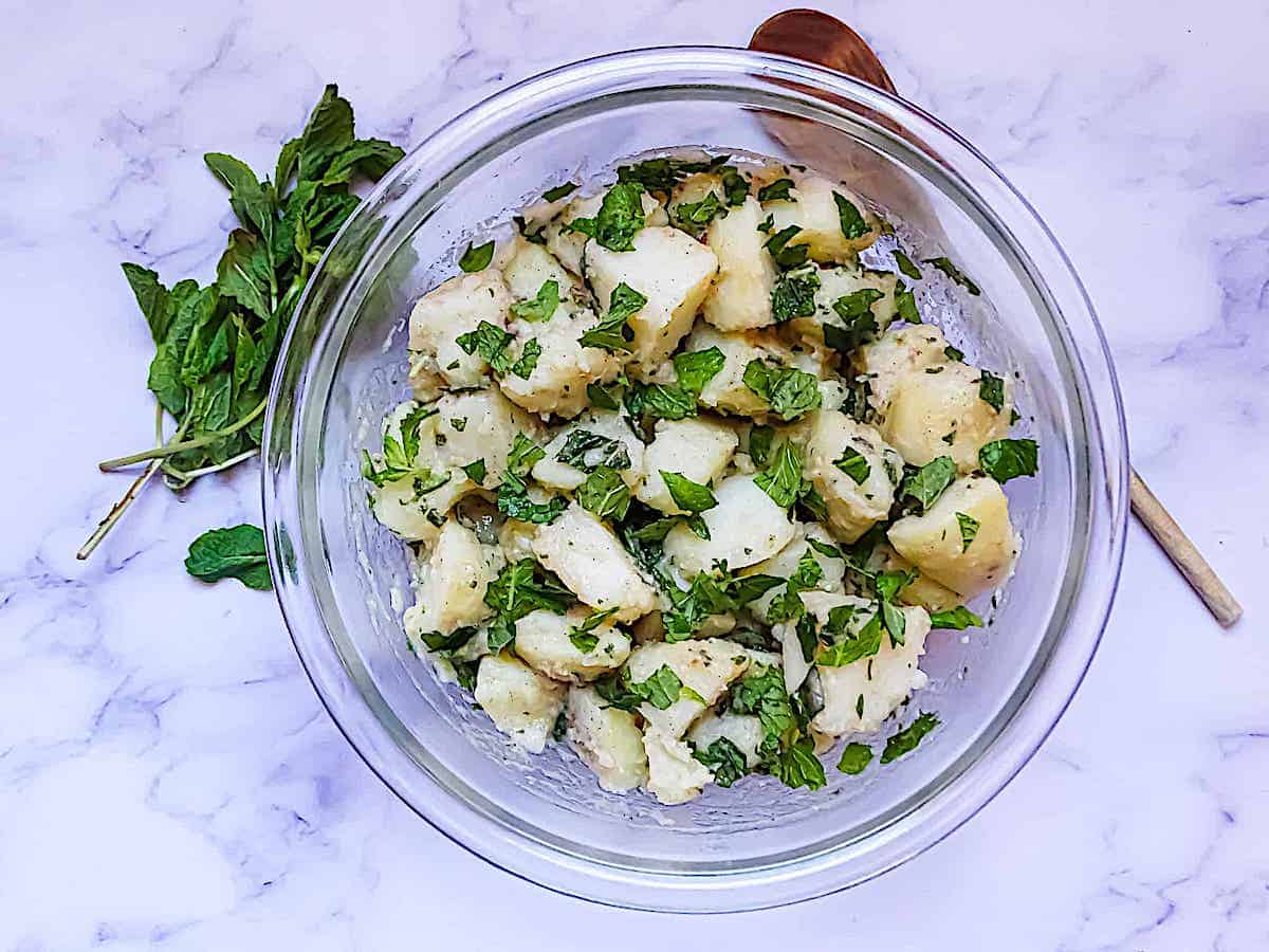 Syrian Potato Salad with lemon and mint in a clear bowl