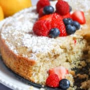 sliced olive oil cake topped with powdered sugar and berries