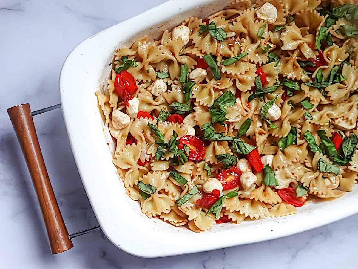 caprese pasta salad in a white serving bowl