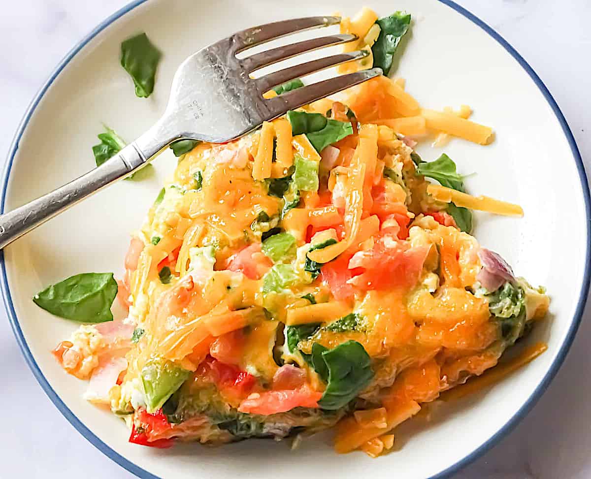 slice of a veggie omelette on a white plate