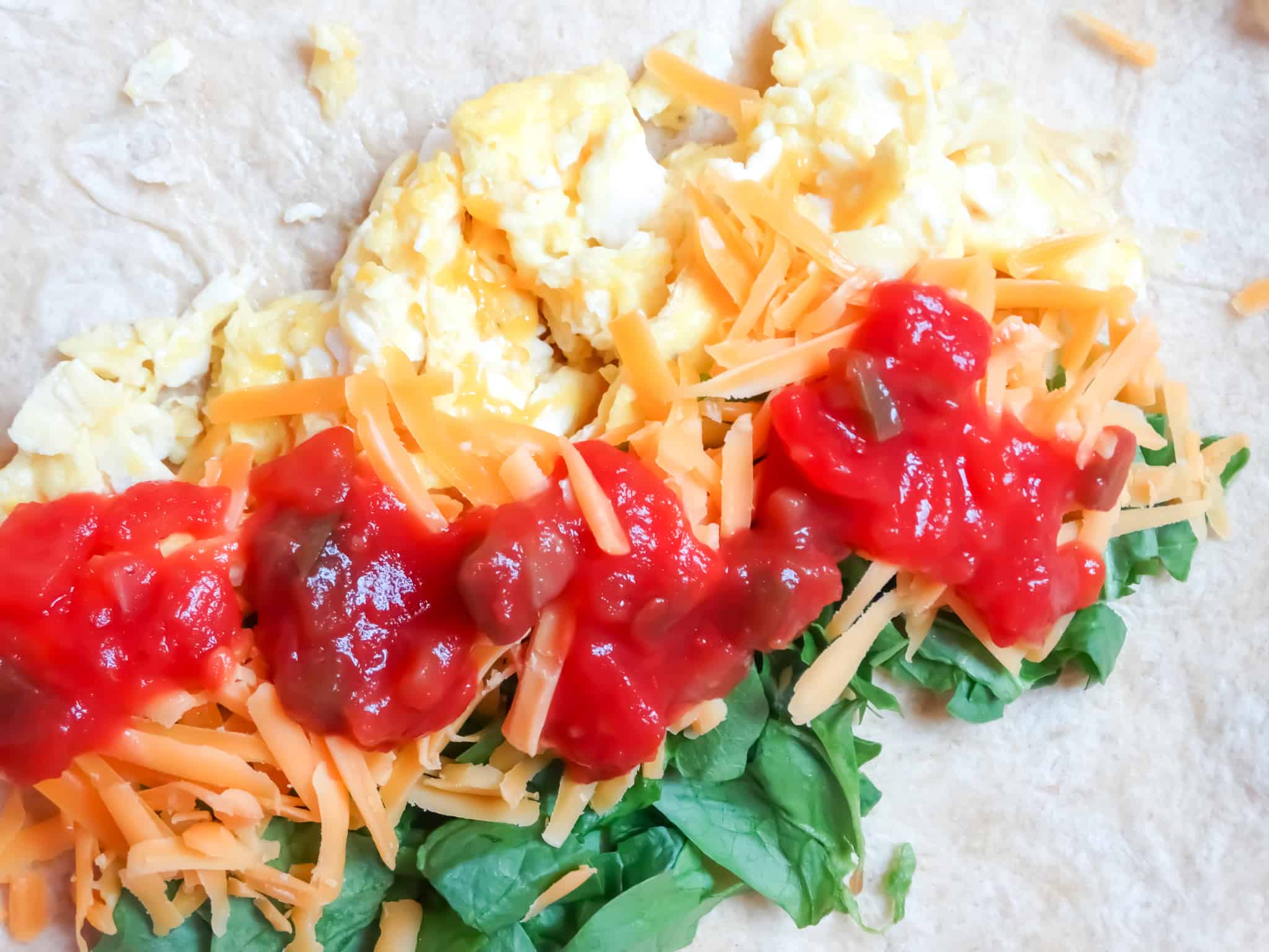 close up of ingredients in a spinach egg breakfast burrito, healthy breakfast ideas
