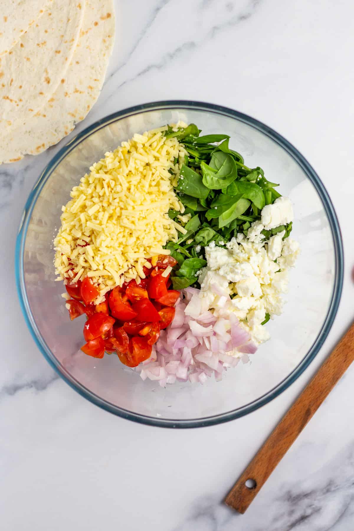 spinach, onion, tomato, cheese in a mixing bowl