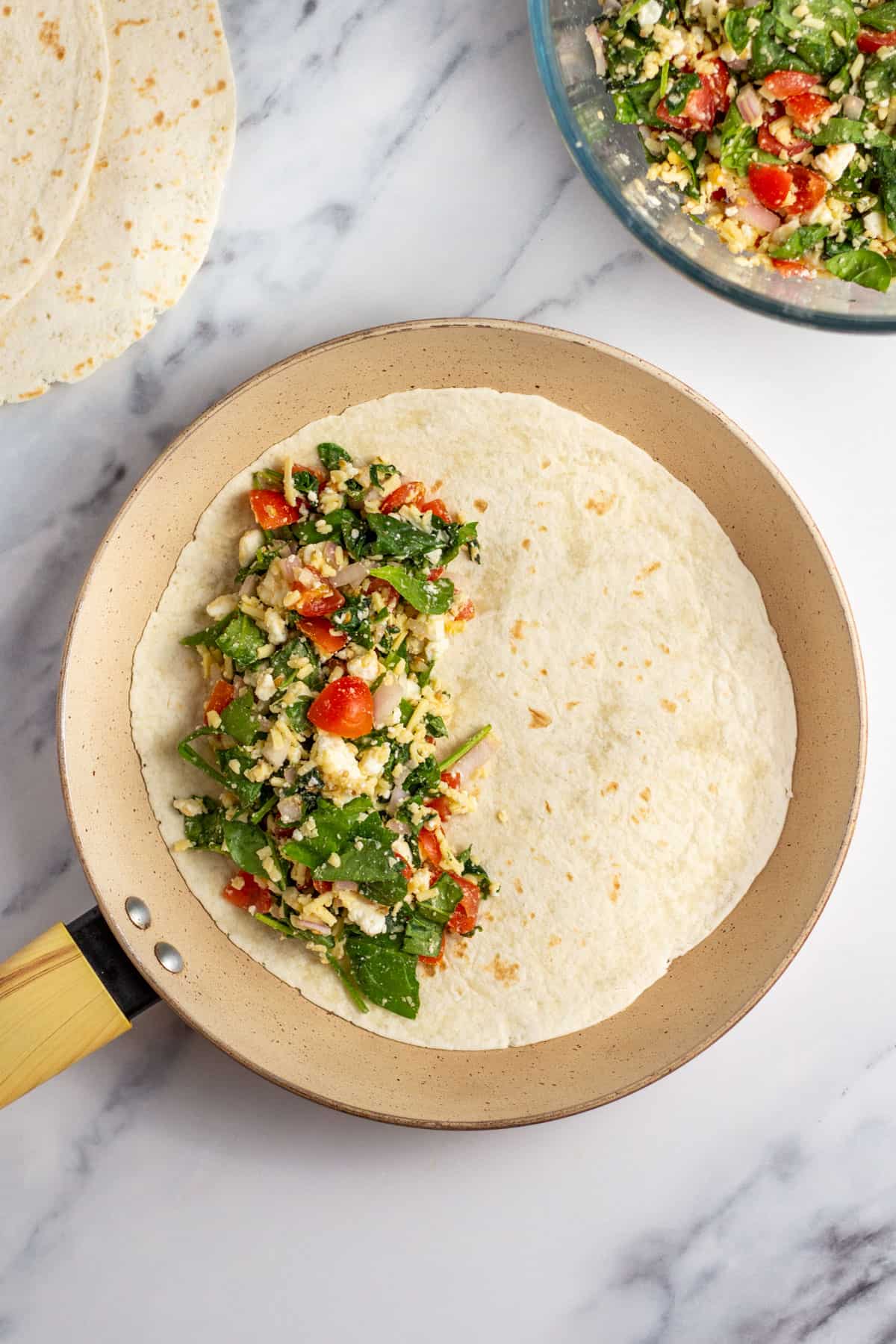 quesadilla stuffing on one side of a tortilla in a pan