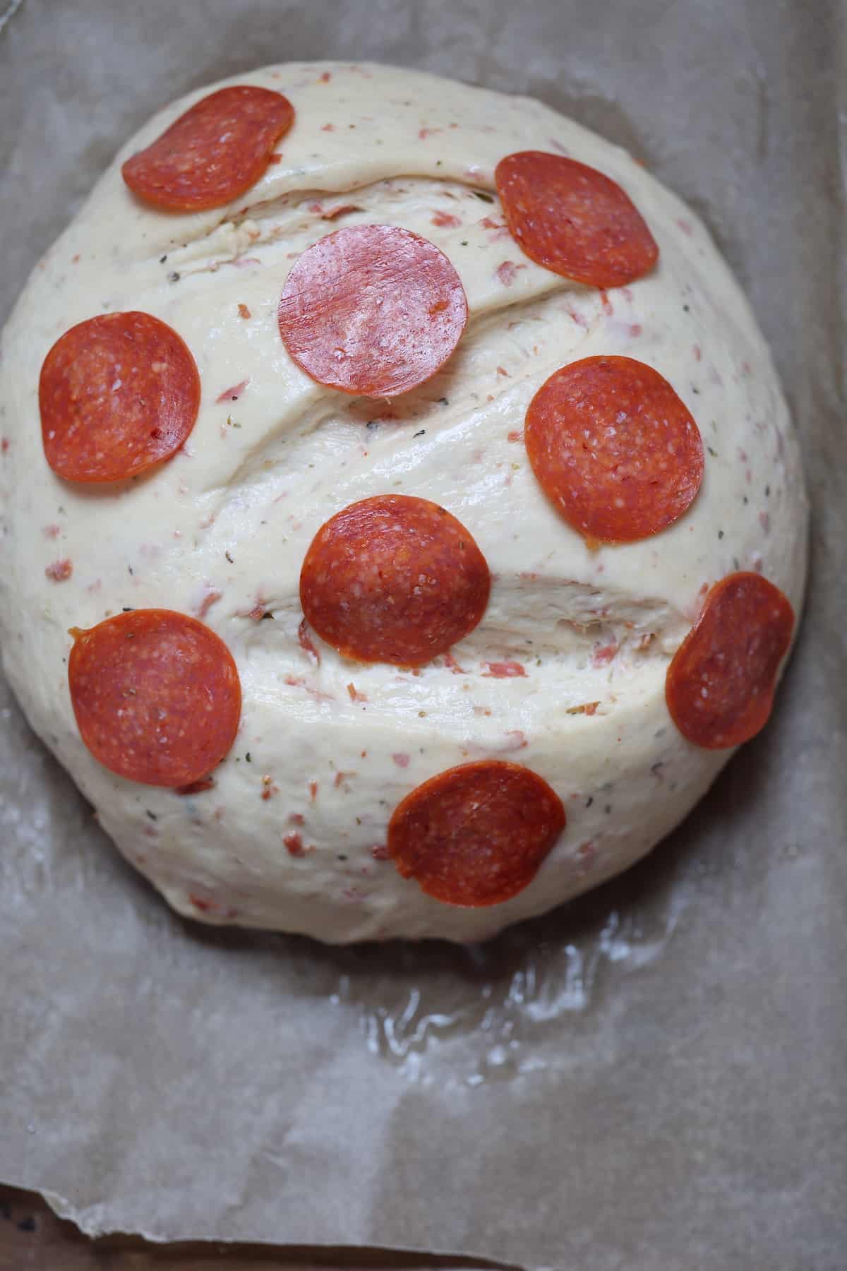 ball of dough with pepperoni slices on top