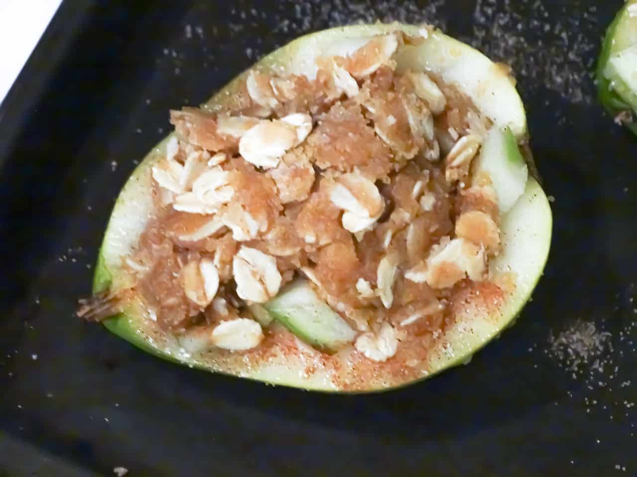 baked pears with apple crisp topping on a grey plate