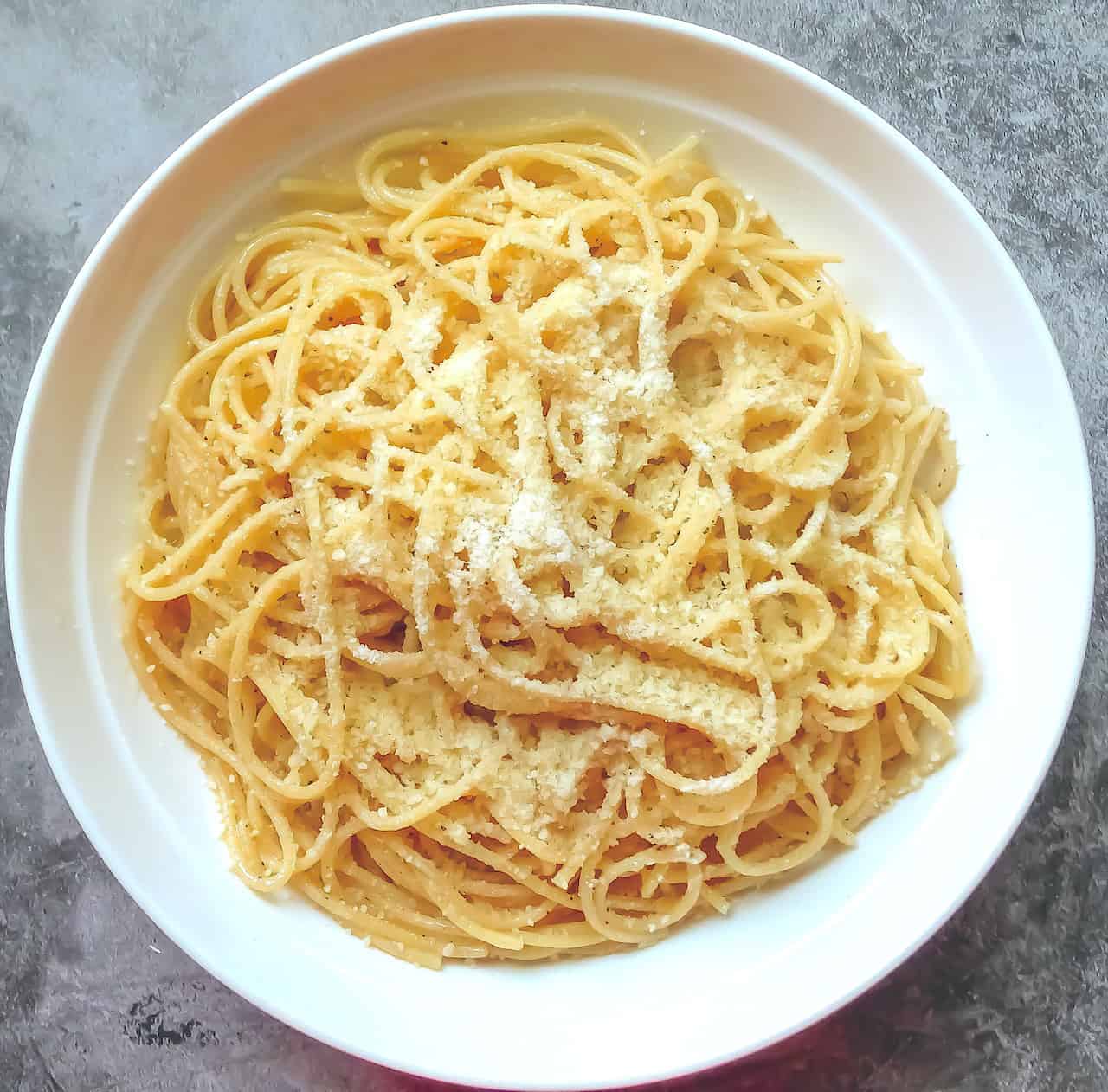 pasta with butter and parmesan in a white serving bowl