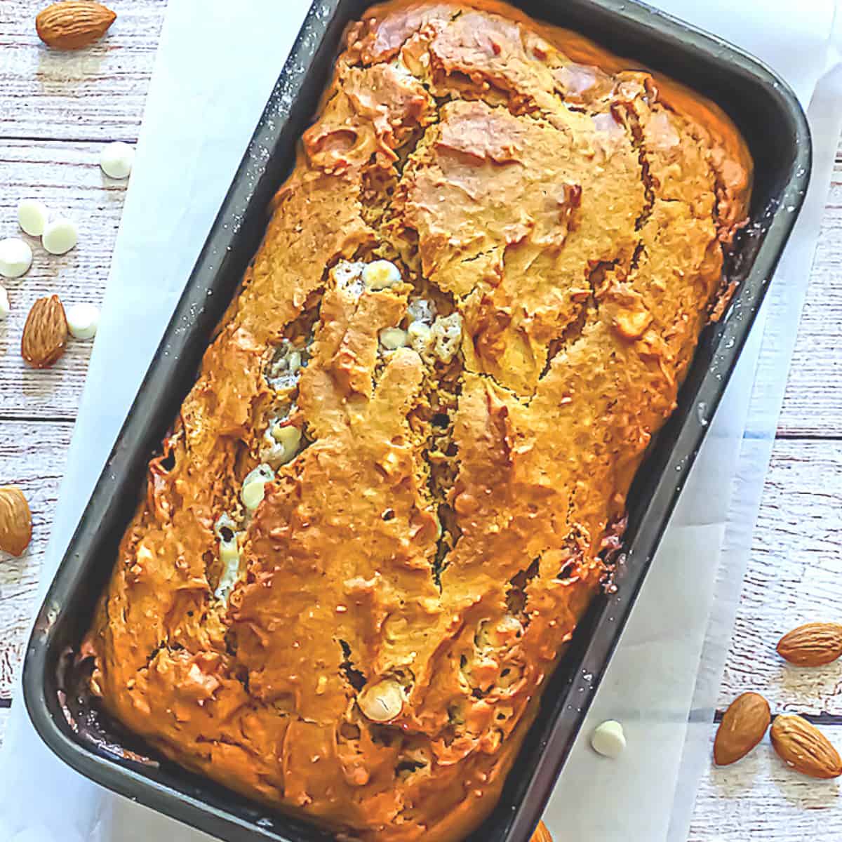 chocolate pumpkin bread topped with almonds in a loaf pan