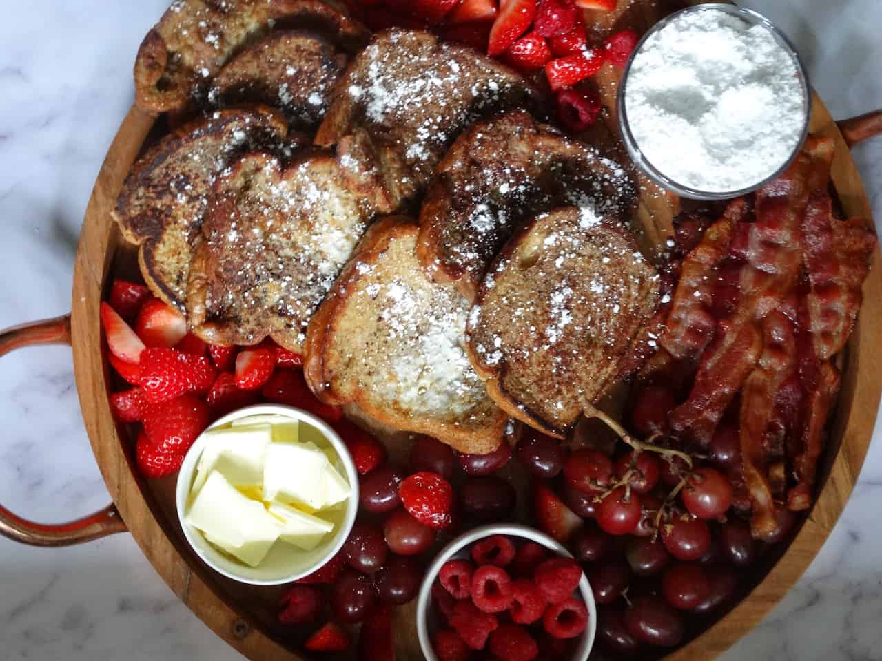 french toast breakfast charcuterie board: grapes, strawberries, and bacon on a charcuterie platter for breakfast 