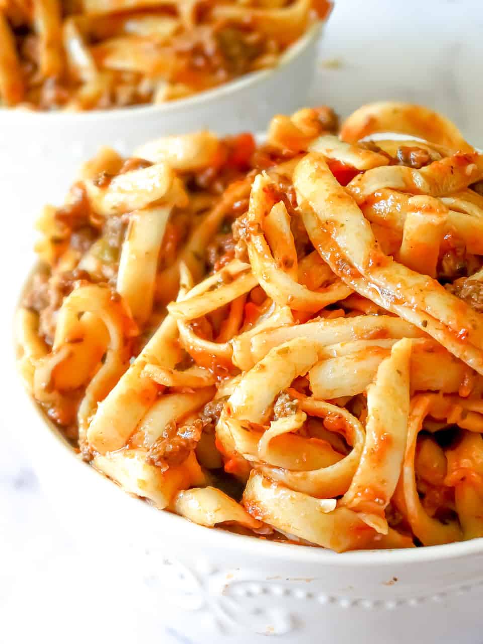 instant pot spaghetti with meat sauce in a white bowl with a white background