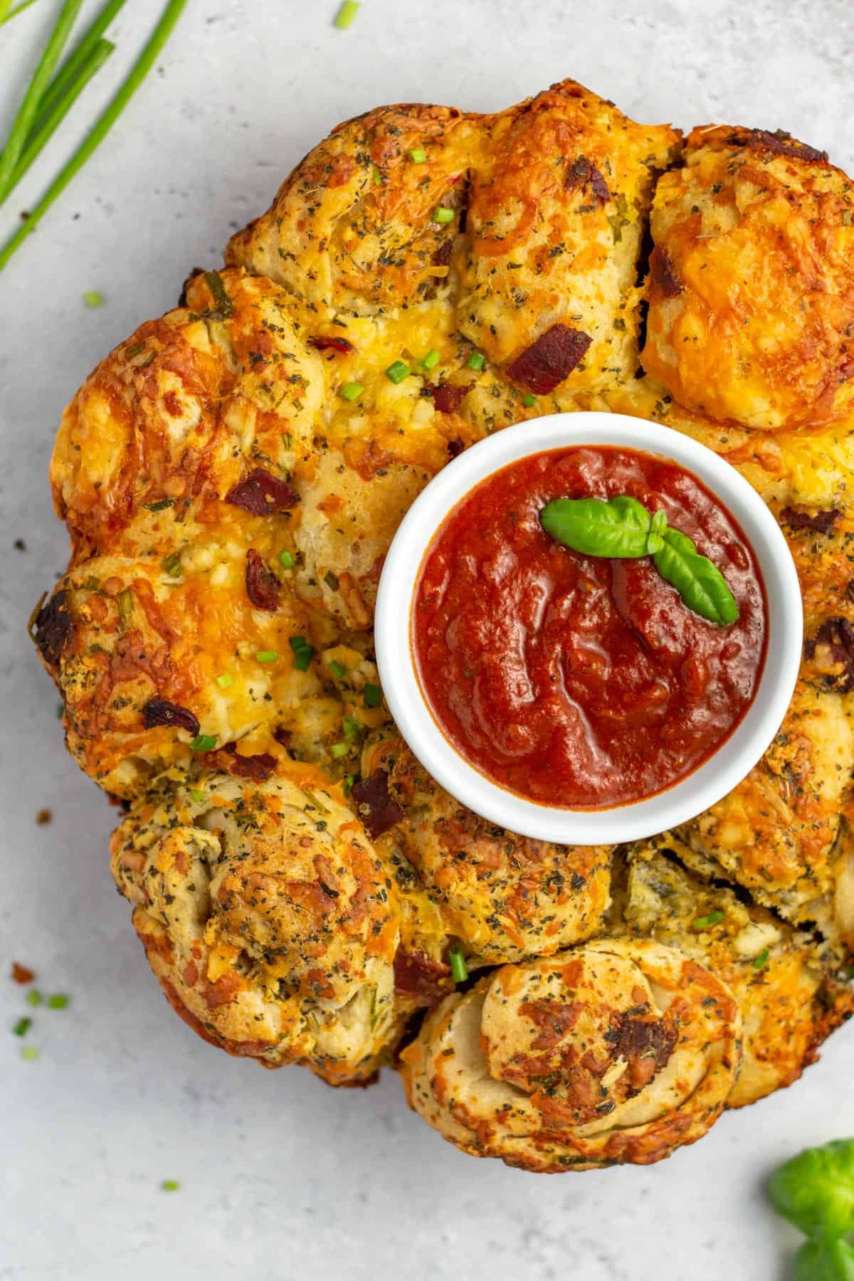 bacon pull apart bread on a white serving dish with dipping sauce