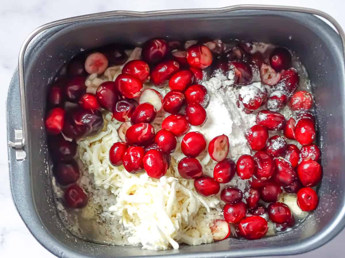 cranberries, flour, brie, parmesan, yeast, sugar, and salt in a bread machine pan