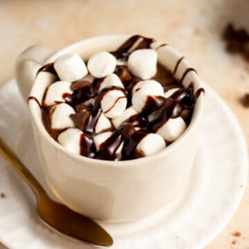 crock pot hot chocolate in a cup with marshmallows and chocolate syrup
