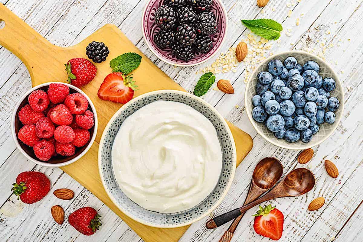 yogurt in a bowl surrounded by fresh berries 