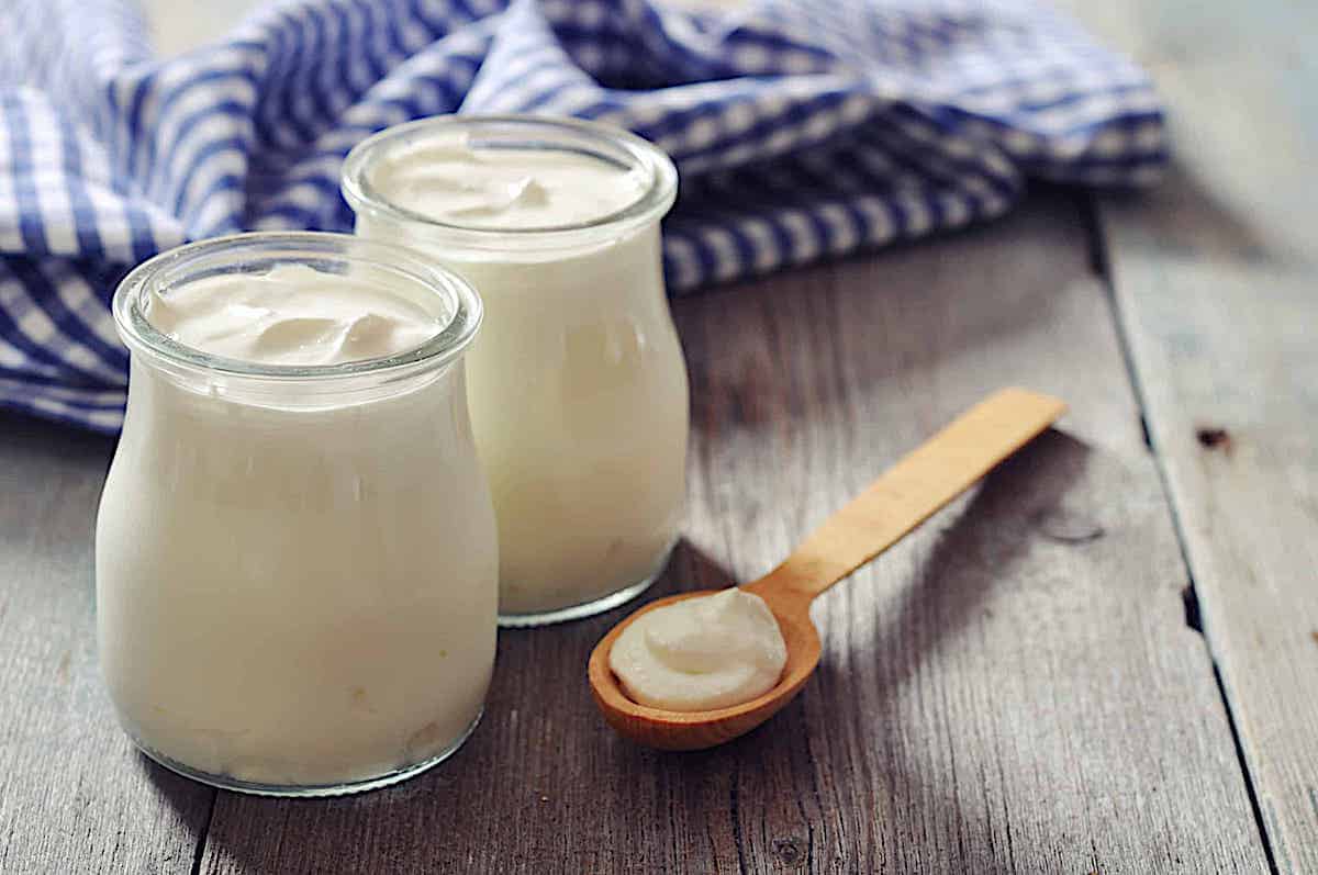 homemade Greek yogurt in 2 parfait jars on a wooden background