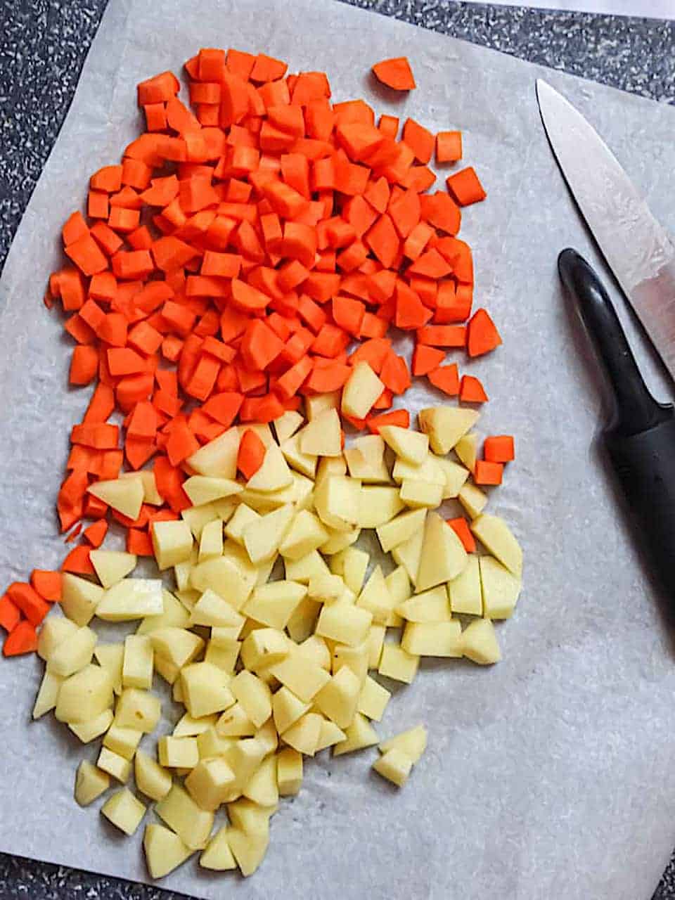 peeled and diced carrots and potatoes on a cutting board