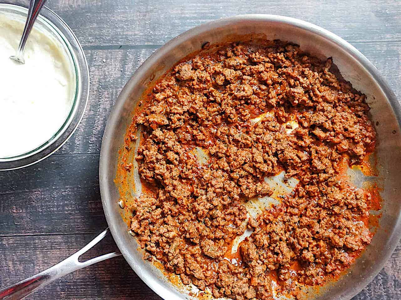 ground beef and seasoning cooking in a pan